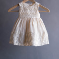 Ivory satin purled dress on wooden hanger