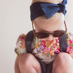 Toddler girl with sunglasses looking at the floor