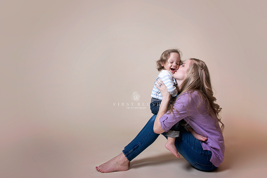A mom kissing her son on the cheek