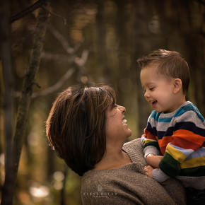Mom holds son and both laugh during a photography mini session in Calgary