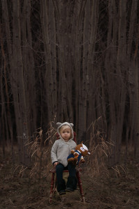 Little girl suffering from hunger sitting on a chair in the forrest feeling hungry.