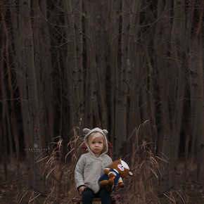 Little girl looking at the camera while sitting on a chair in the forrest feeling hunger.