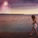 A young girl walks along the beach at dusk with fireworks going off in the background near Red Deer Alberta.