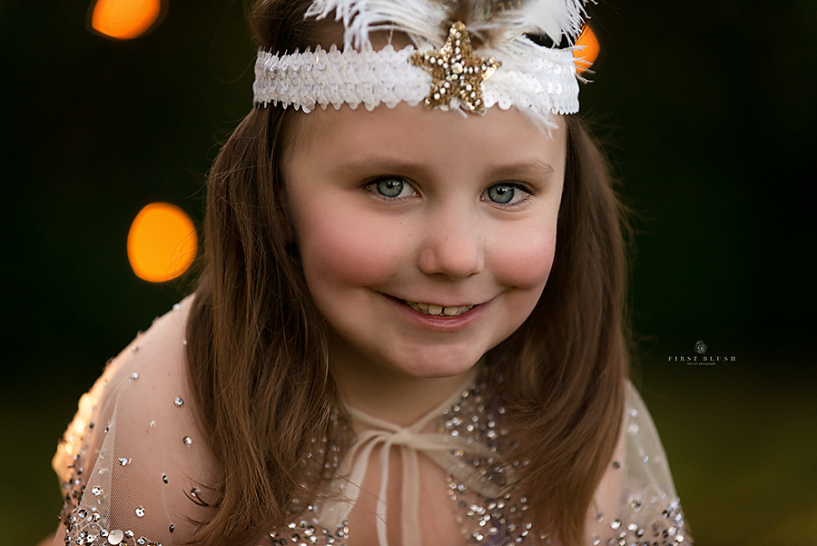 Little girl smiles at the camera using First Blush philosophy near Red Deer Alberta